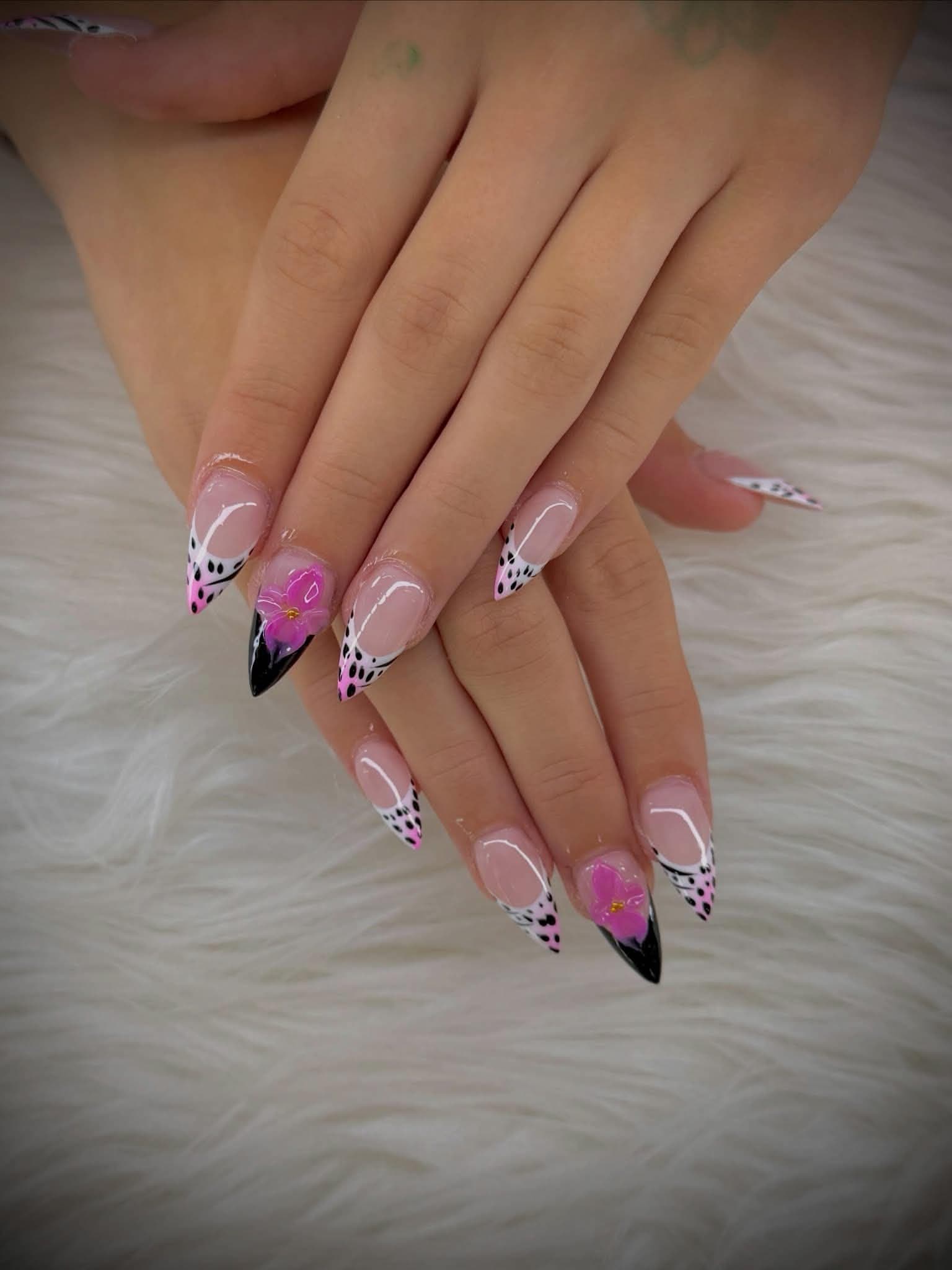Stiletto nails with black and white dalmatian tips and 3D pink flowers