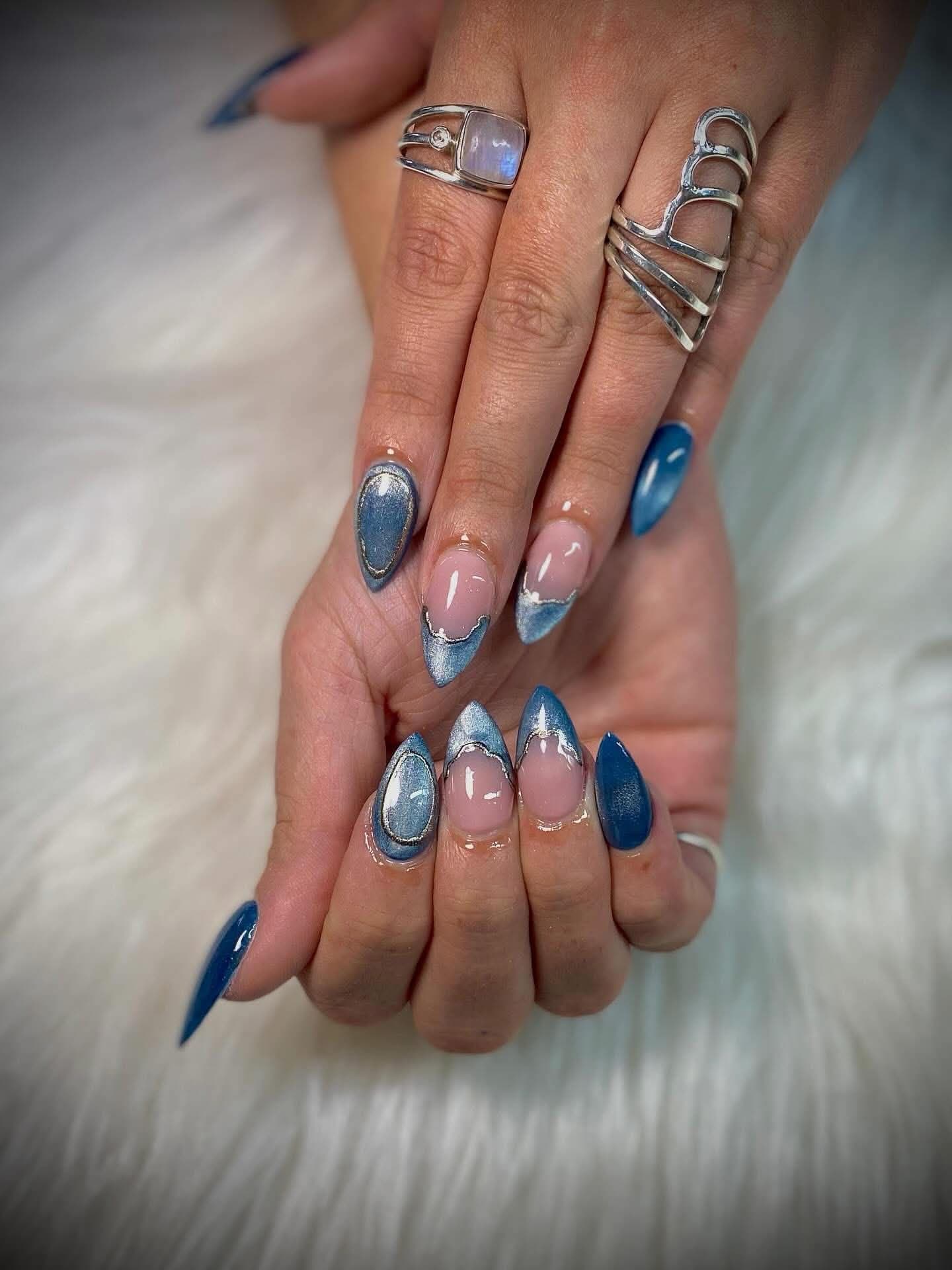 Almond nails in denim blue with silver chrome french tips and cat-eye accents