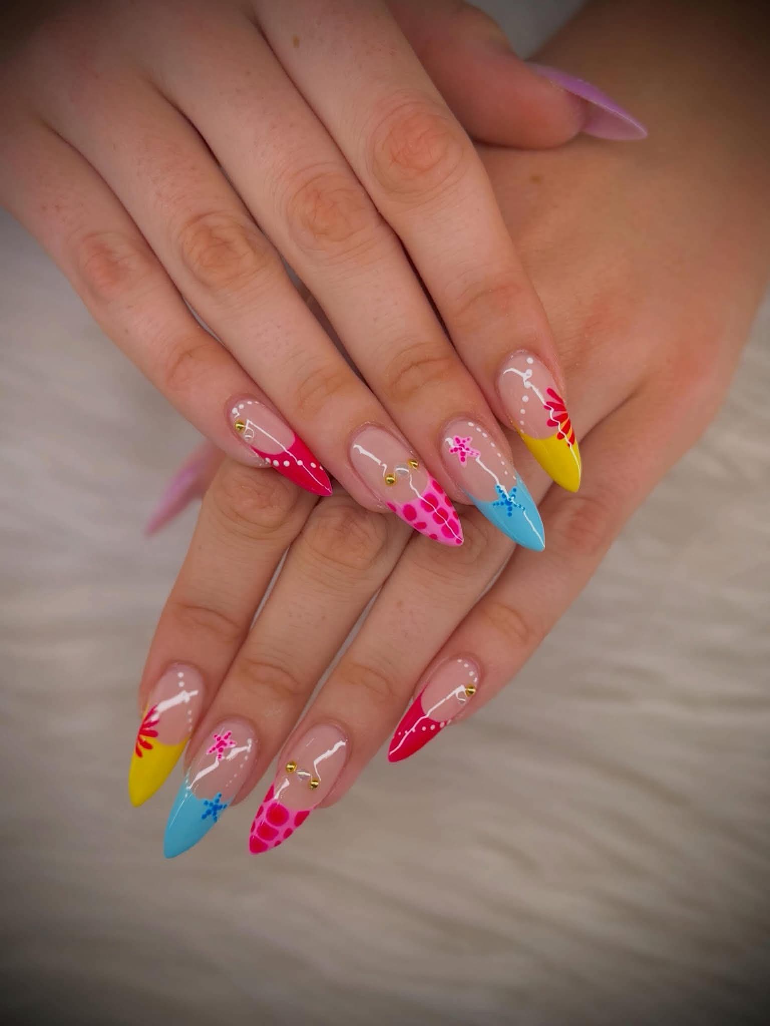 Almond nails with yellow, blue and pink tips, starfish and dot detailing